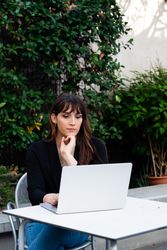 Transgender woman engineer writing code on laptop