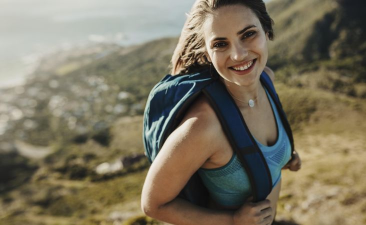 Woman with backpack hiking up a mountain