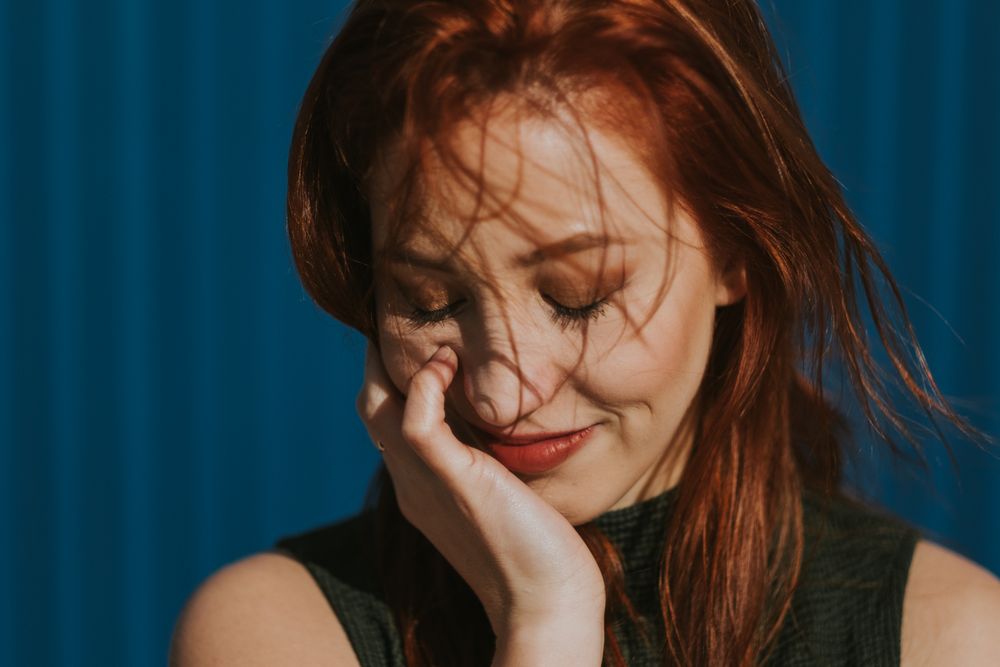 Smiling woman squinting in sun and enjoying weather