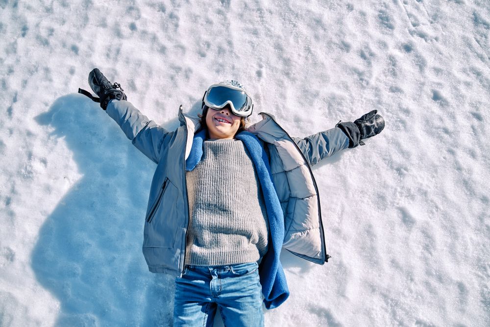 Cheerful boy lying on snow