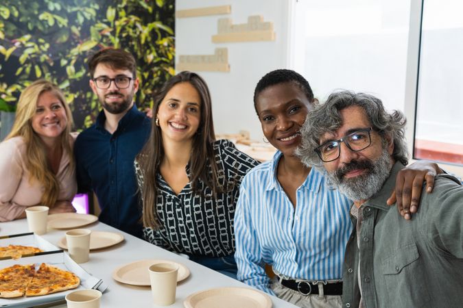 Cheerful multiethnic friends taking selfie during lunch