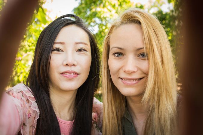 Multiracial friends taking selfie in park