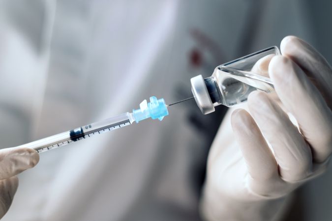injecting injection vaccine vaccination medicine covid into a syringe woman nurse. Close-up