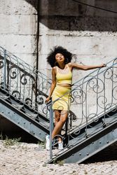 Stylish Black female leaning on railing outdoors