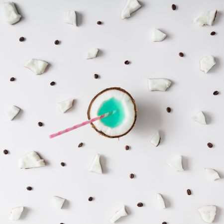 Coconut half with straw pattern on light background