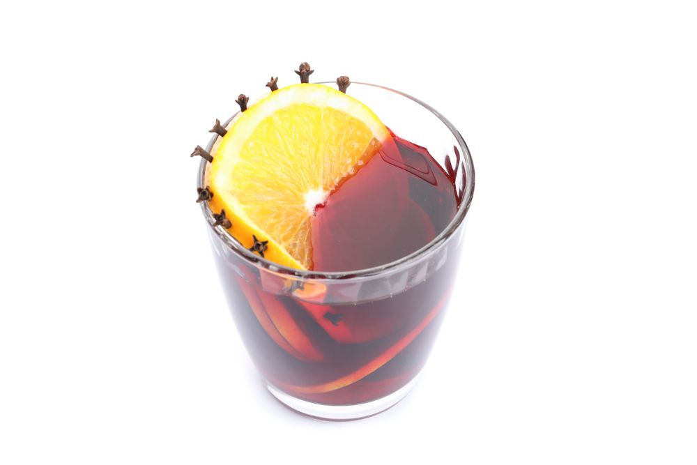 Glass of tasty mulled wine with orange isolated on blank background