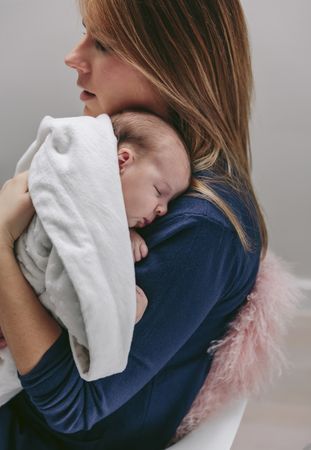 Mother hugging her sleeping baby girl