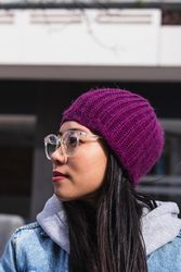 Asian brunette woman with long hair leaning on the wall and looking away