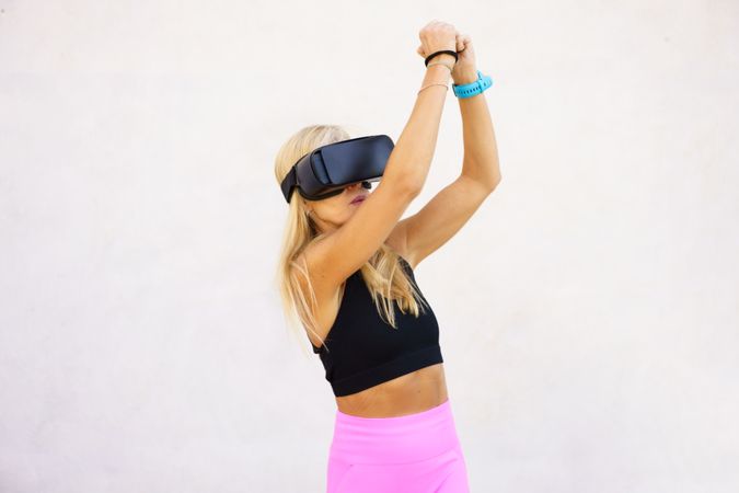 Fit woman using VR headset to play sports game