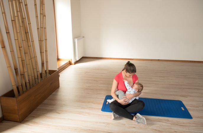 Mother feeding baby in gym