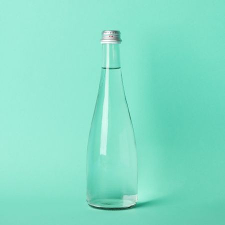 Full glass water bottle in green room