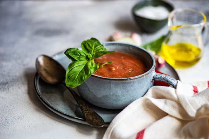 Cup of gazpacho soup with basil, garlic, pepper and olive oil