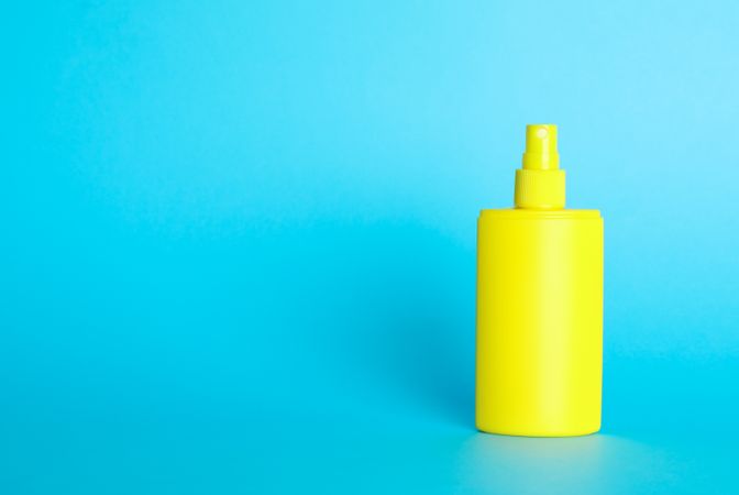 Sunscreen spray on color background, space for text