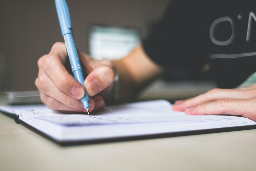 Person writing on a notebook paper
