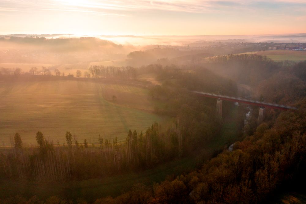Sunrise scenery, drone aerial view, with railway bridge crossing river in nature