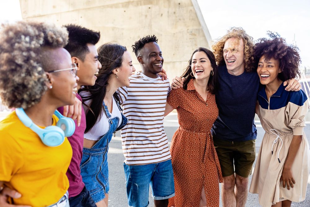 Large group of young adults smiling and standing outside