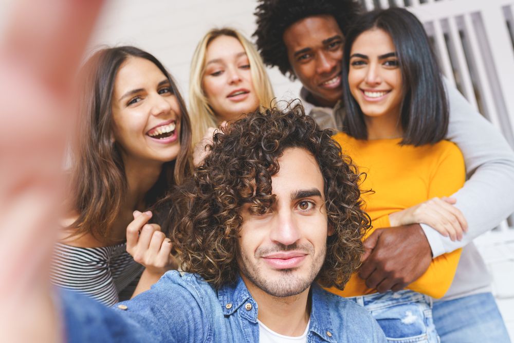 Smiling group of friends posing for a selfie outside