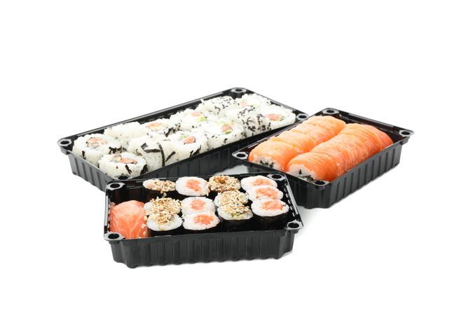 Containers with sushi isolated on plain background. Food delivery