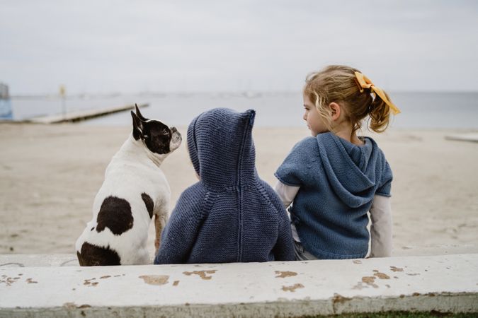 Kids hugging dog on beach