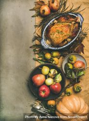 Roast turkey in roasting pan, on table with fall leaves and fruit, vertical composition, copy space 0yjGW5