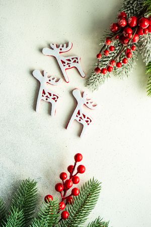 Reindeer decorations surrounded by fir branches on counter