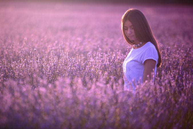 Woman in blooming field during sunset