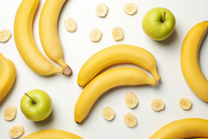 Bananas and apples on light background, top view. Fresh fruit