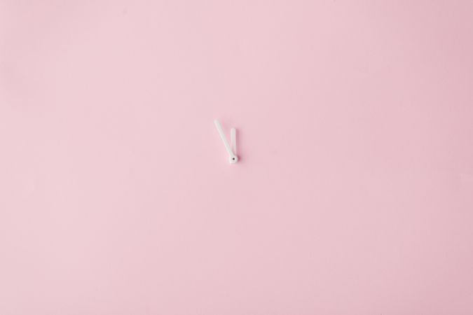 Clock hands on pastel pink painted wall