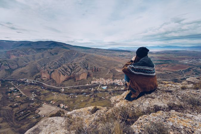 Faceless woman resting on mountain top