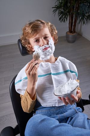 Boy shaving in a barbershop