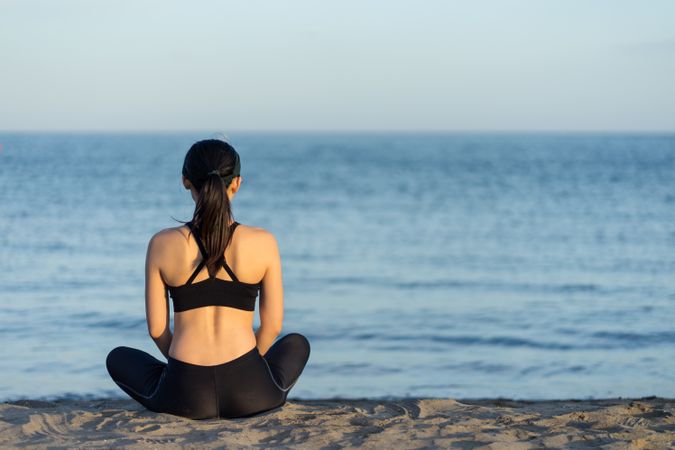 Sportive woman sitting in the on beach