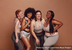 Diverse workout friends smiling against brown background bDgr84