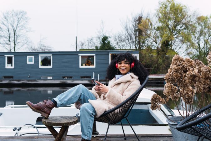 Cheerful Black woman listening to music at lakeside