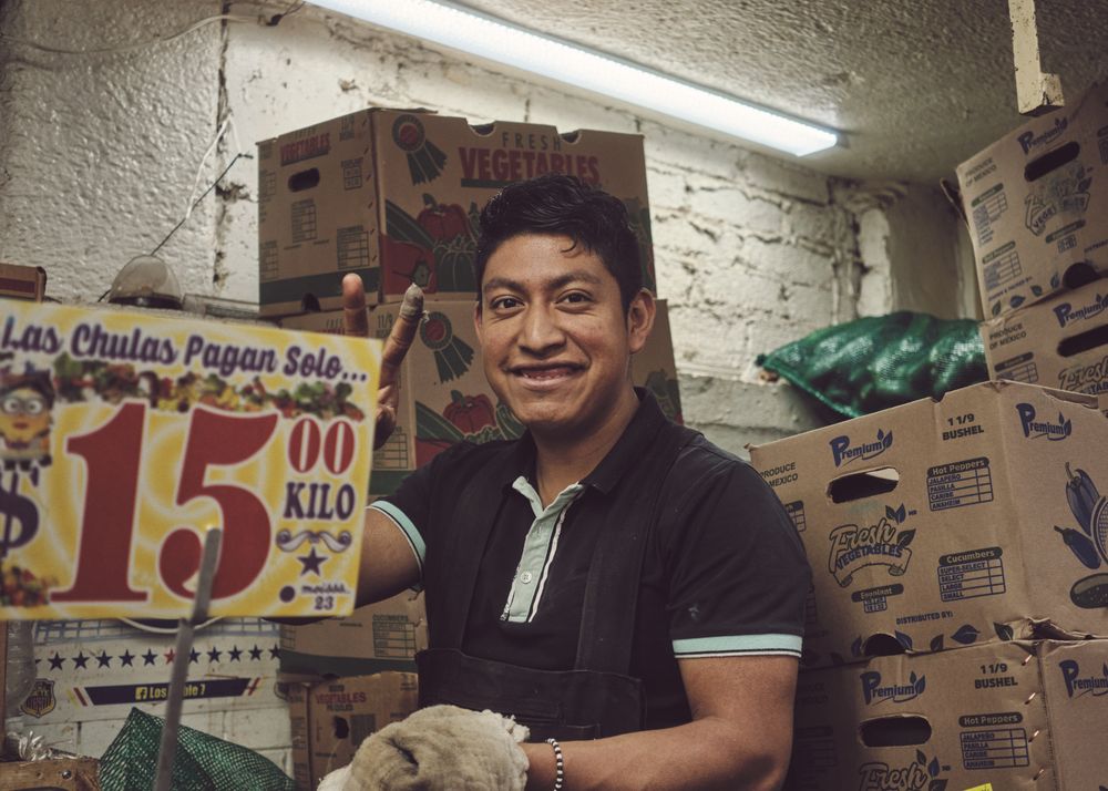 Man among fruit boxes in store in Mexico City