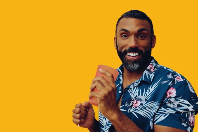 Happy male with a drink in a orange cup with copy space