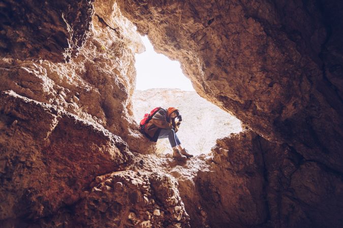 Relaxed tourist woman entering mountain cave