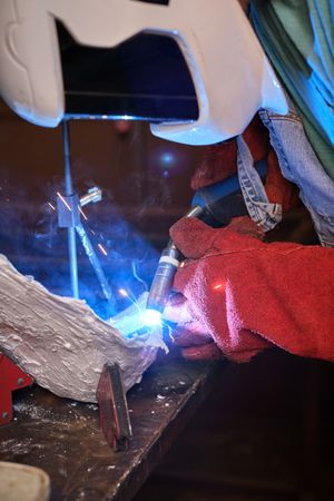 Manual worker using welding torch at factory