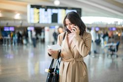 Woman using smartphone at airport
