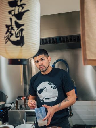 Handsome male stirring sauce in kitchen