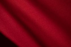 Diagonal Wavy Red fabric background texture. shiny, glossy and elegant background.
