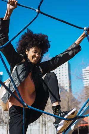 Woman with afro hair climbing by children's attractions.