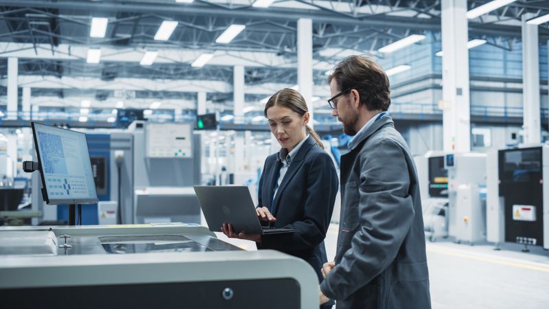 Woman and man with laptop at store check out