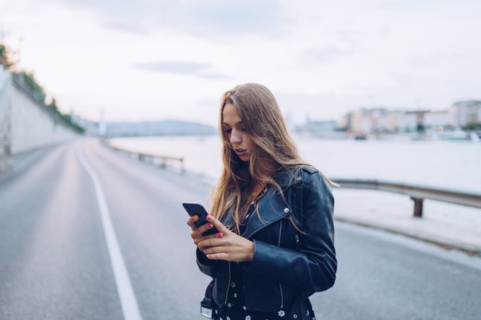 Long haired stylish woman browsing smartphone