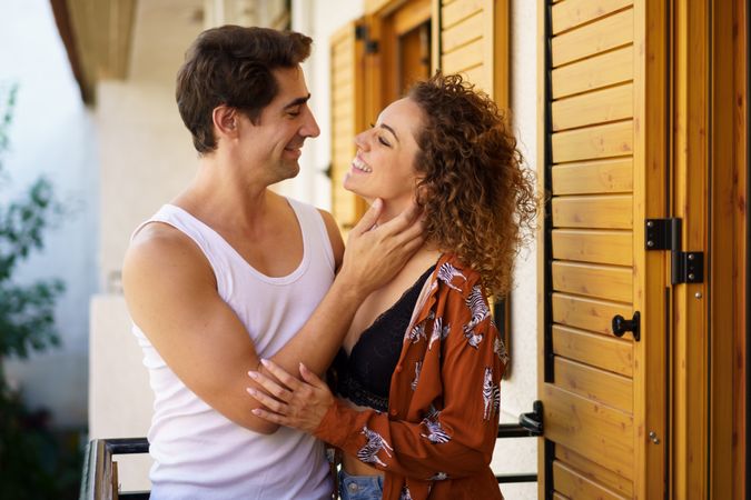 Affectionate couple embracing on home balcony