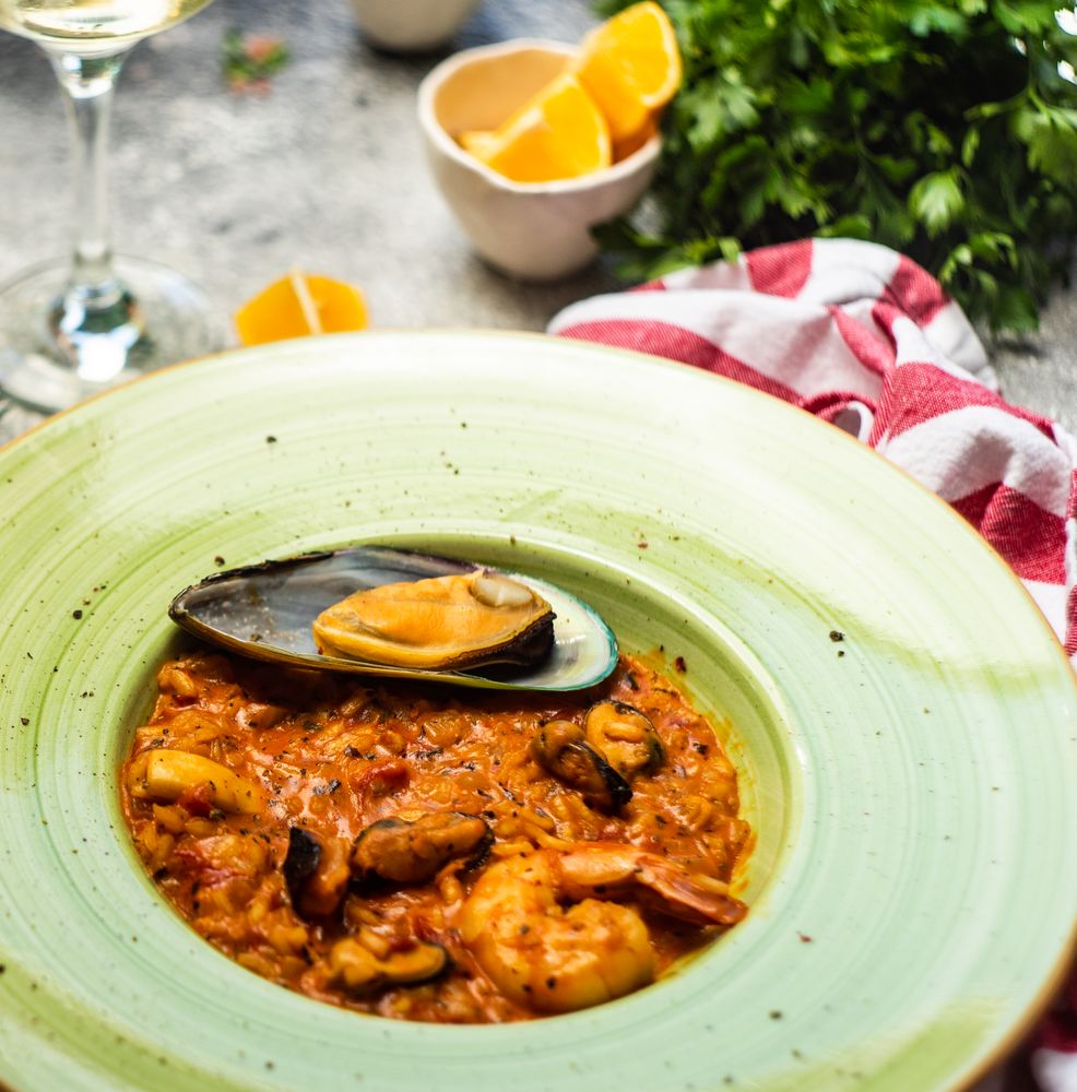 Risotto with sea food served with chill wine, parsley and lemon