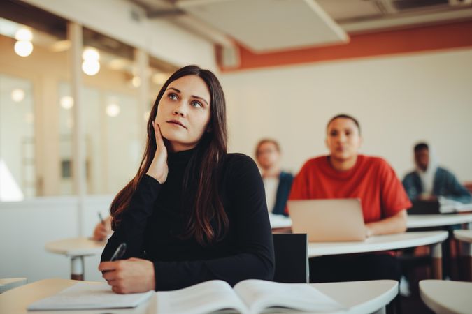 Young woman thinking in classroom during lecture