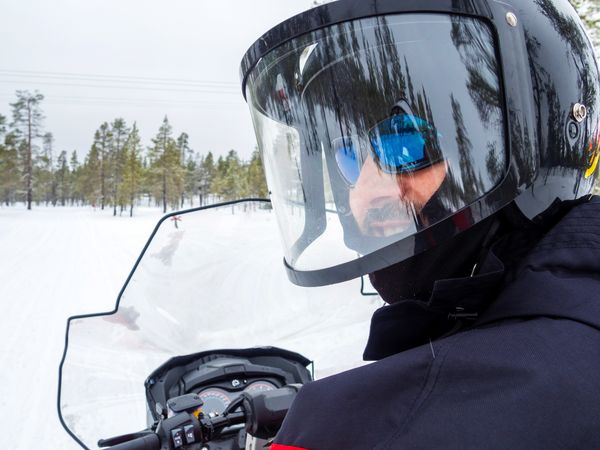 Man in helmet sitting on snowmobile