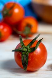 A bunch of red tomatoes are on a wooden table