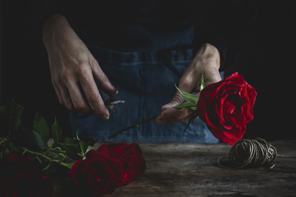 Unrecognizable woman making a bouquet of red roses