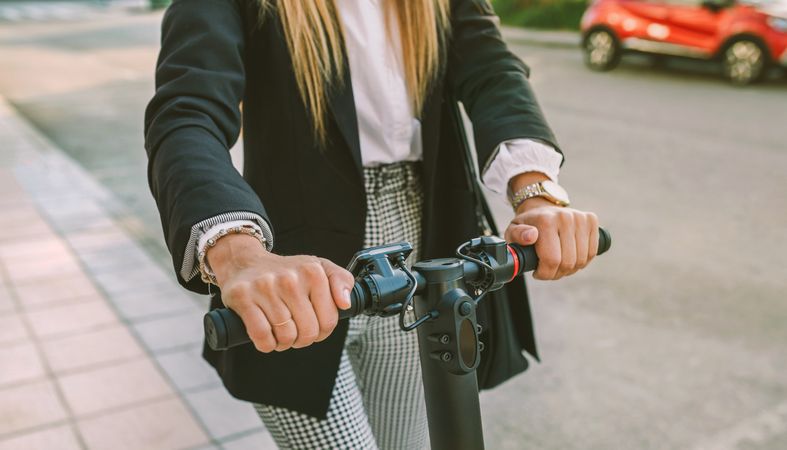 Unrecognizable businesswoman with e-scooter outdoors